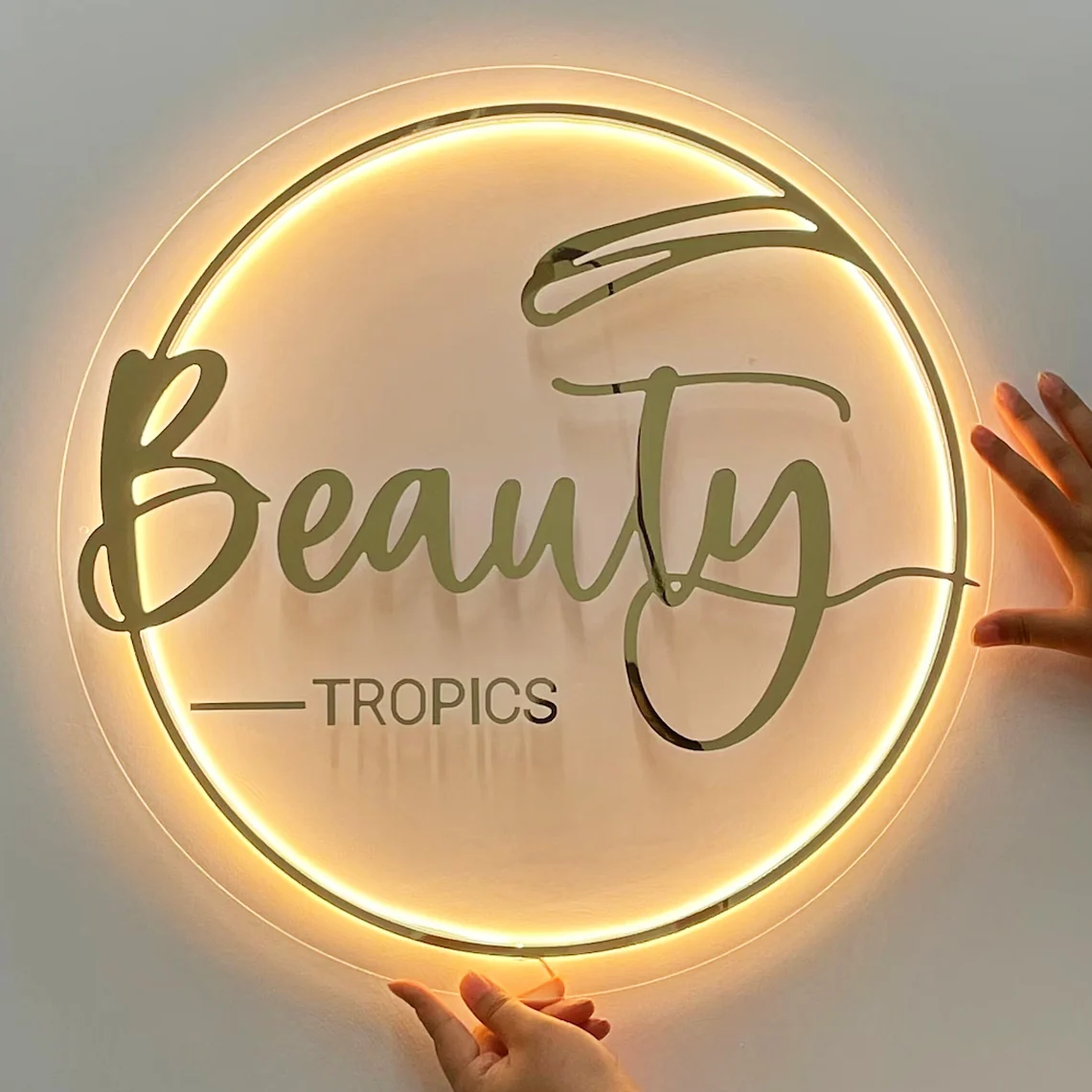 : Circular acrylic sign glowing with LED backlighting in an elegant business display.