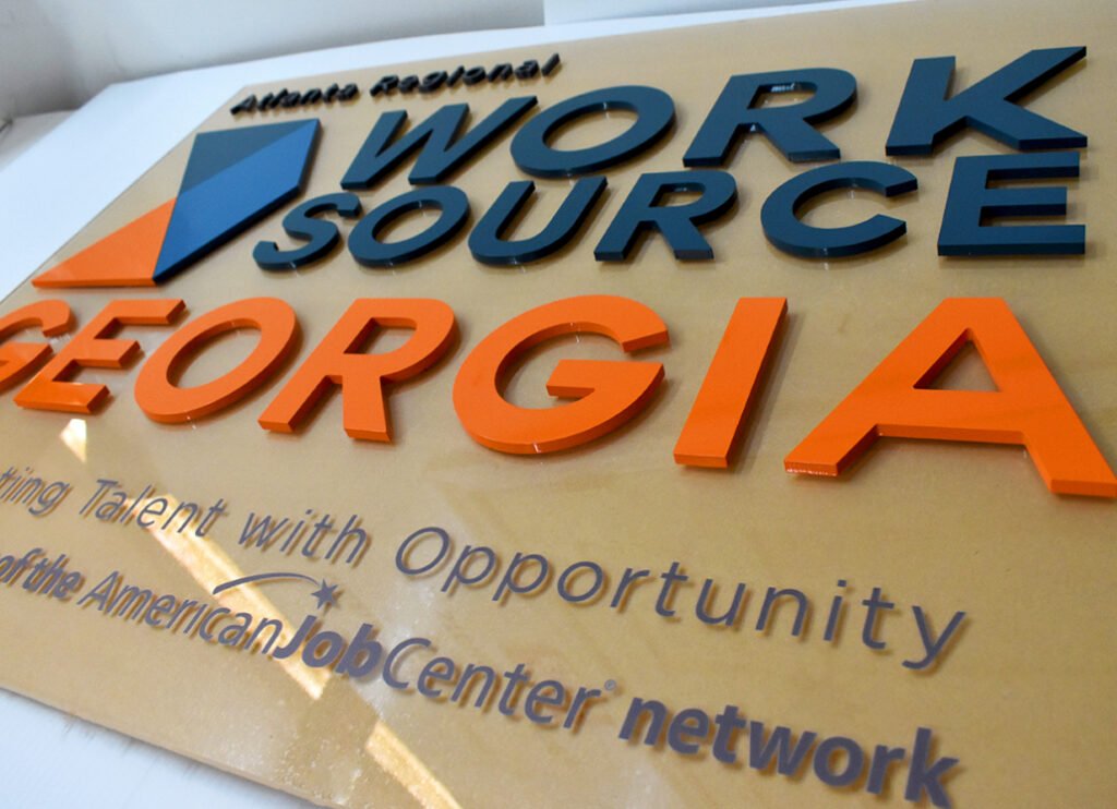 Large 3D Acrylic Sign Board with red and black raised letters on building facade”