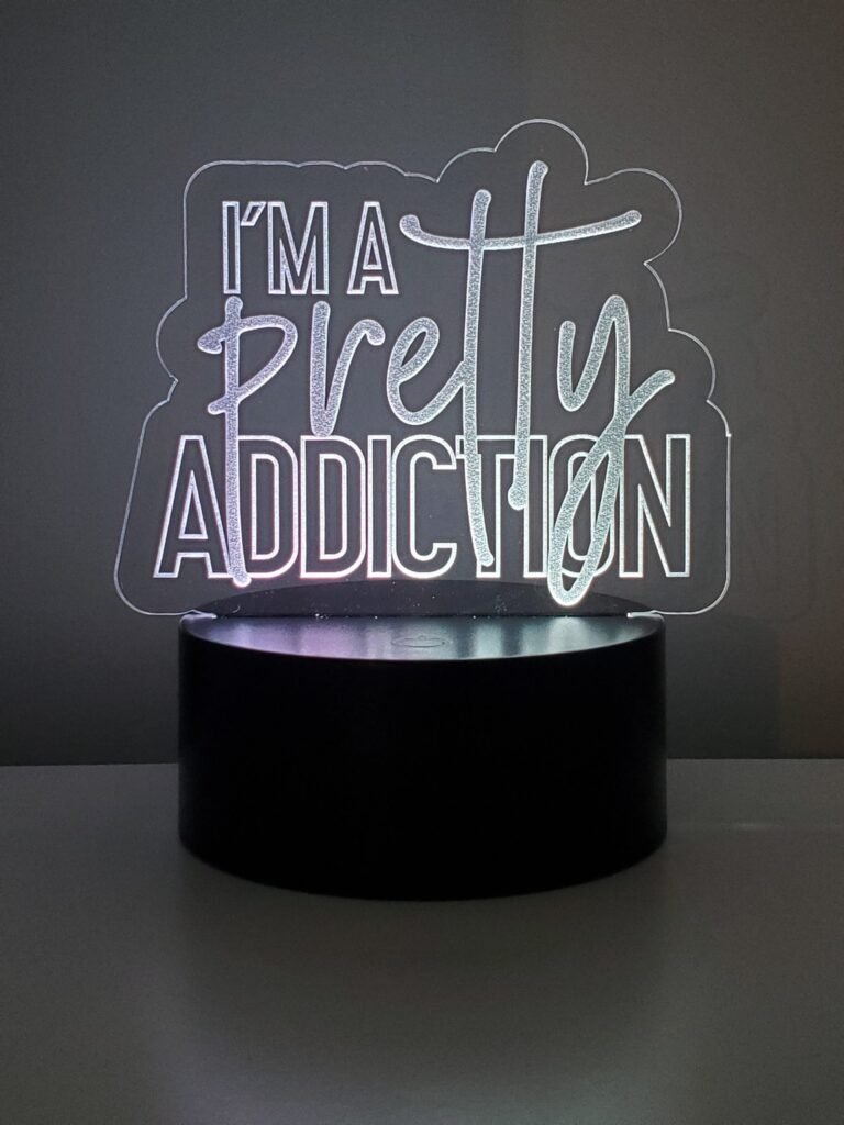 Personalised acrylic LED logo sign glowing on a LED base on a desk